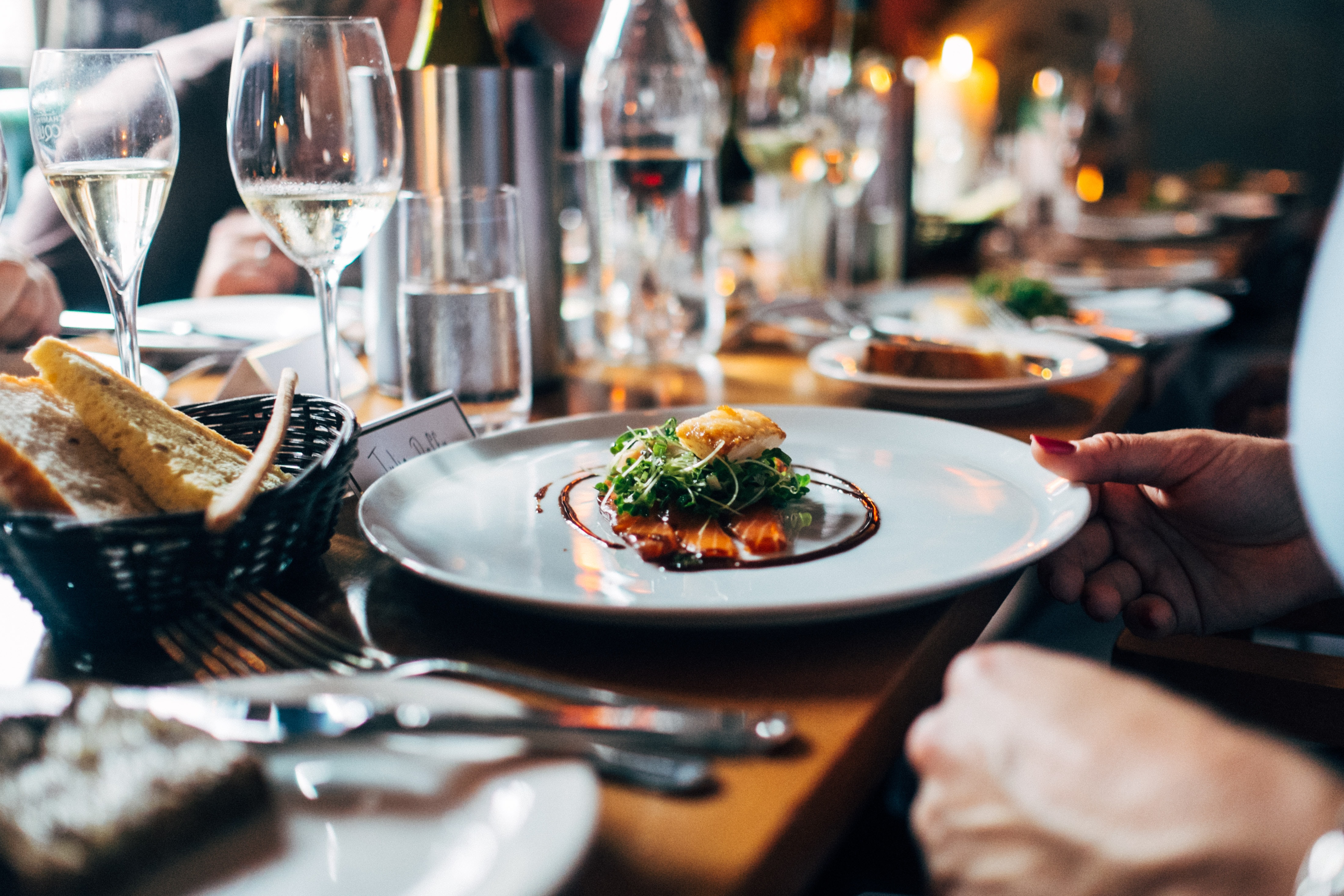 Photo d'une table de restaurant avec un plat gastronomique, du pain et des coupes